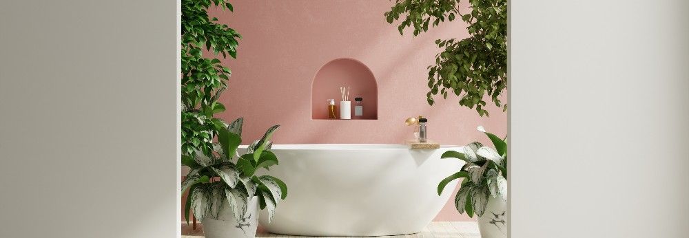 verschiedene Pflanzen um Badewanne vor pinker Wand